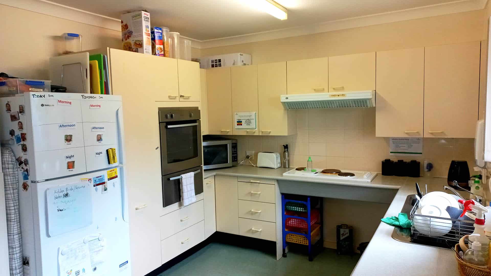 The light coloured kitchen with cupboards and cooking facilities.
