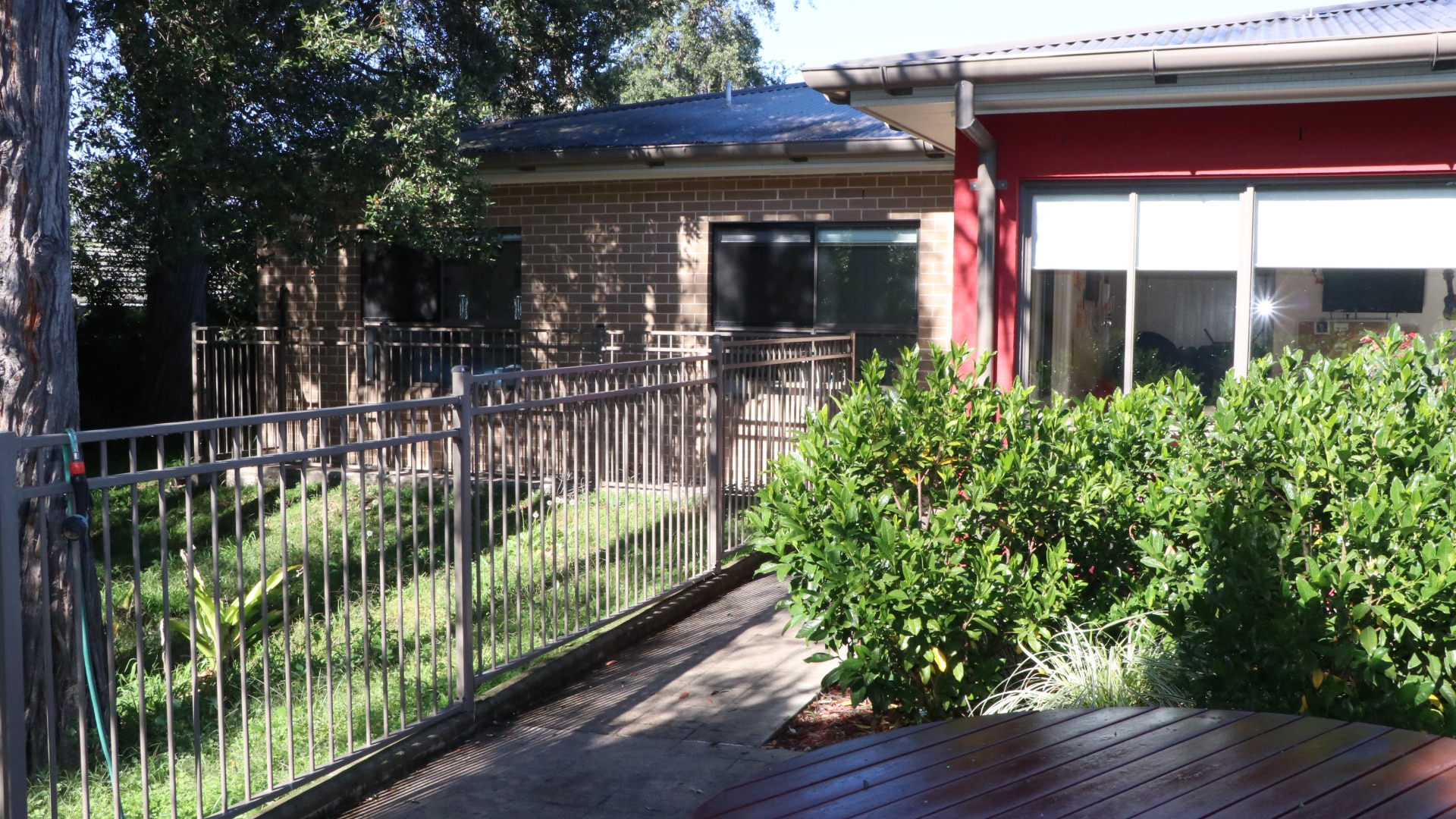 Outdoor fenced grass area and garden outside the Asquith property