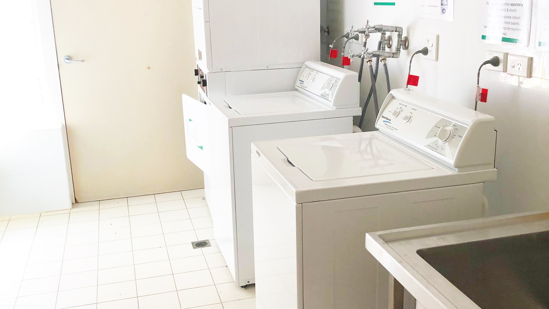 The laundry with two washing machines and dryers.