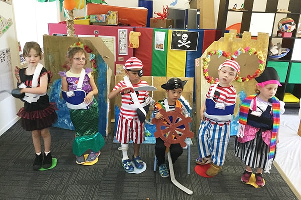 A group of young kids dressed up in a workshop