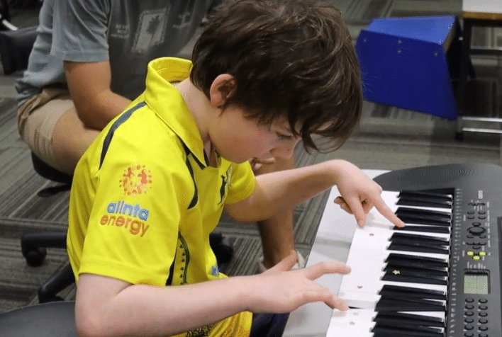 young boy playing the keyboard