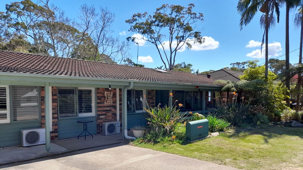 Outside view of the front of the house, grassed yard and garden