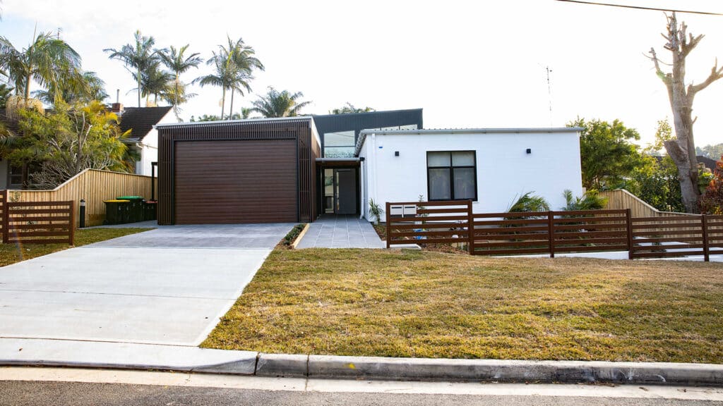Front view of the house with secure garage and small fenced garden