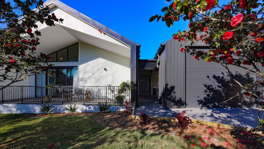 Front view of Cromer 3 property, a modern house with a high pitched roof, secure garage and and grassed yard