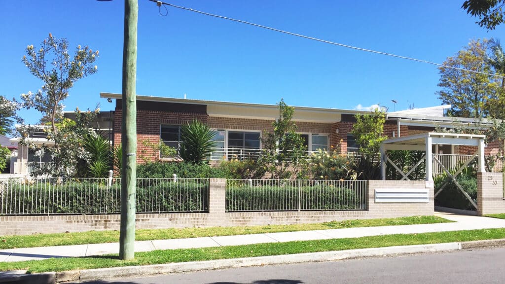 Front view of the units with entrance and fenced garden