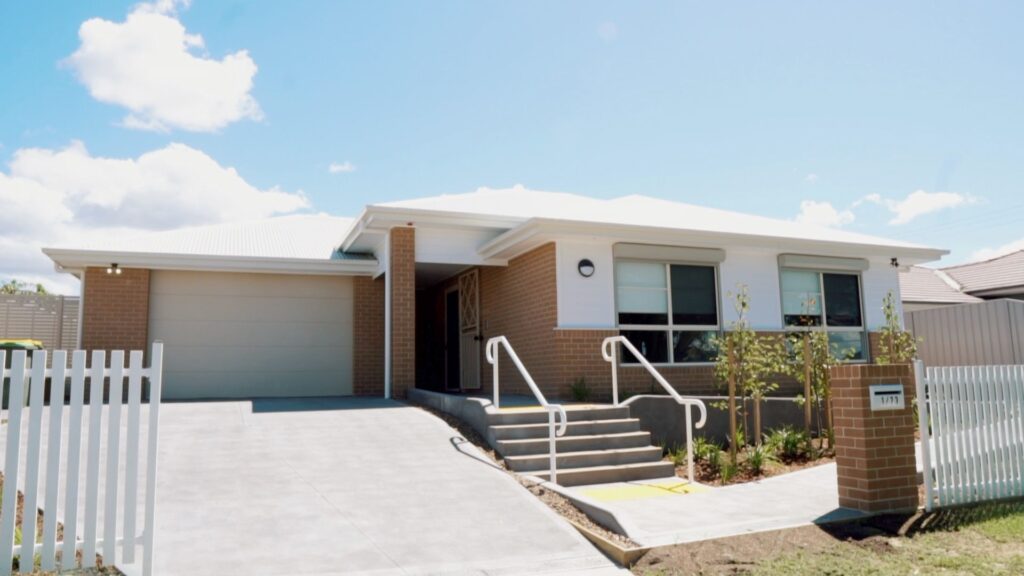 Front view of the house with secure garage and garden