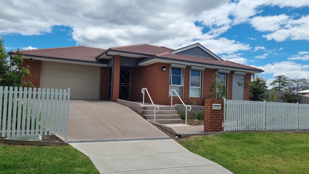 Front view of the house with secure garage and garden