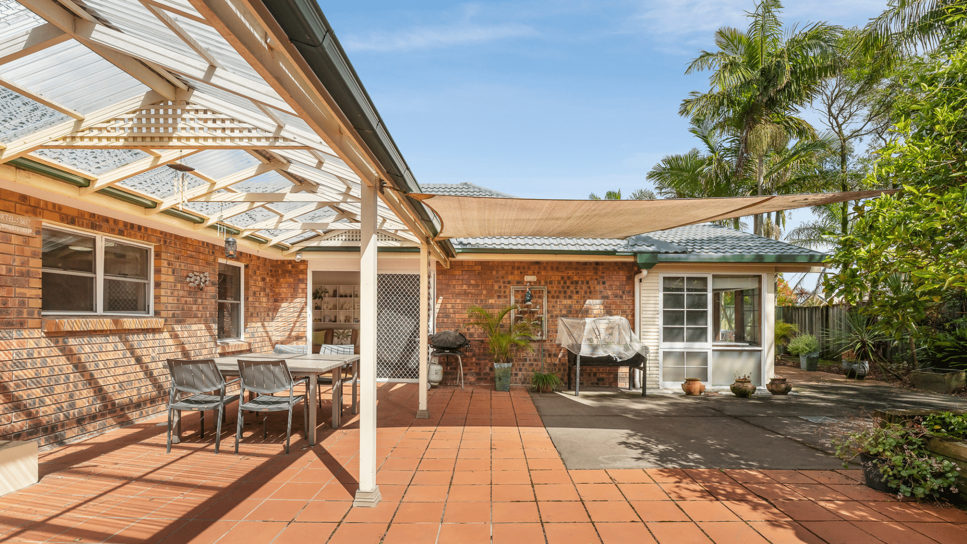 Backyard with a paved and covered outdoor area and surrounding garden