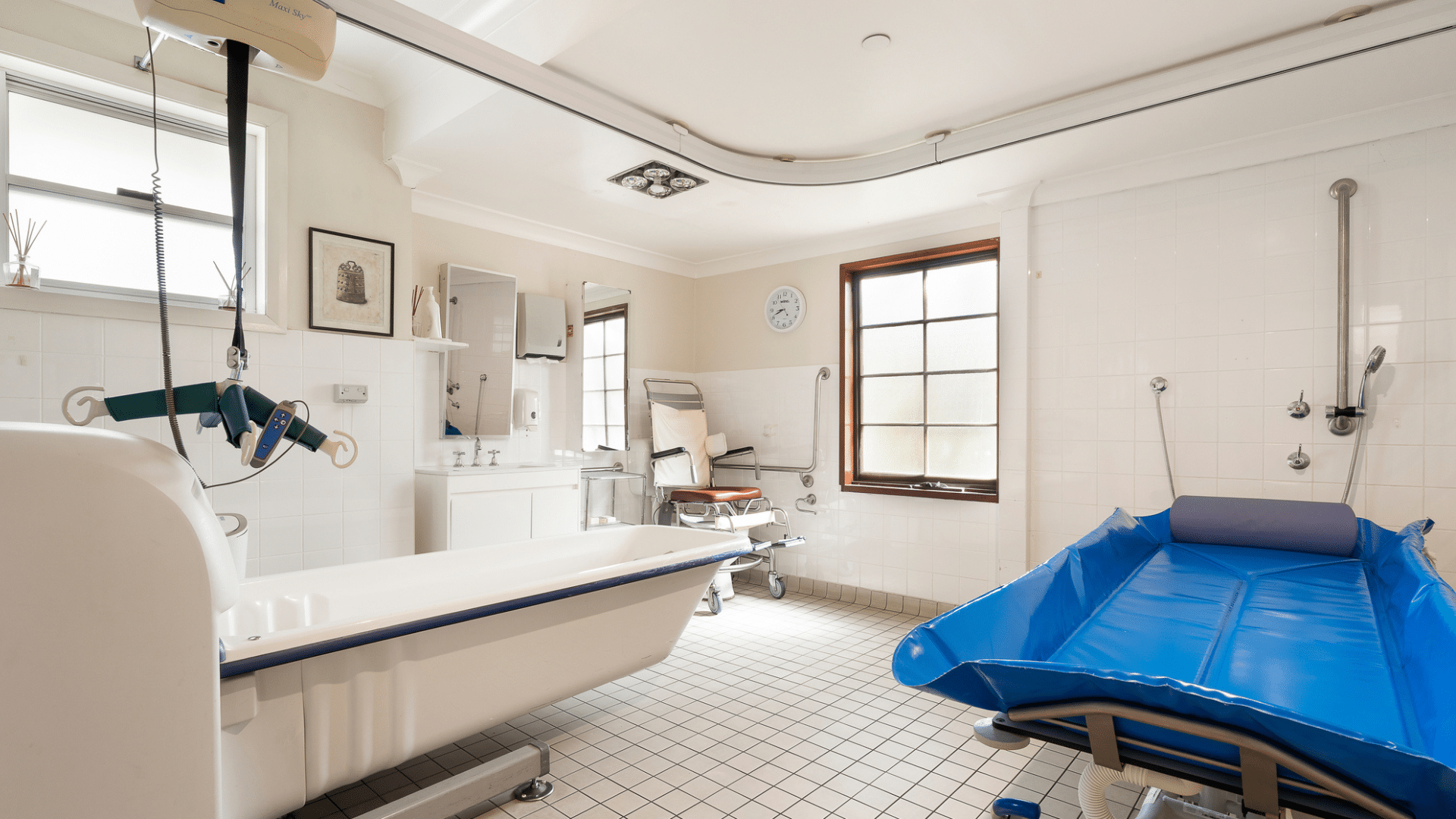 Accessible bathroom with natural light, handrails, ceiling hoist, open shower and accessible bath