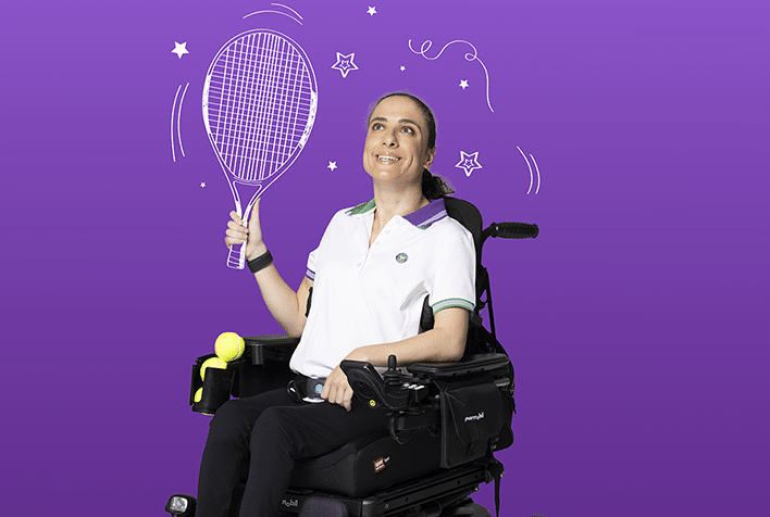 Lia sitting in her wheelchair holding a tennis racket