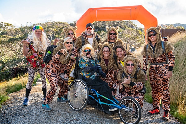 group of people from the krazy kosci climb outside in the bush in tiger print animal fancy dress