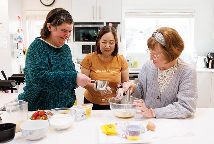 Three females cooking together in the kitchen
