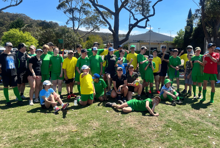 A group of young participants dressed mostly in green and yellow at the football swim-tri camp.