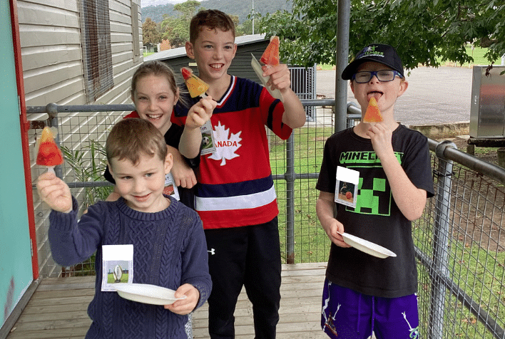 A group of four kids holding iceblocks