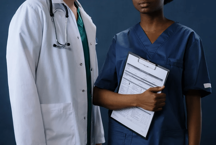 Two doctors standing side by side wearing scrubs