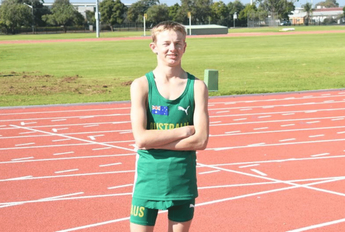 Zac Harding wearing his Australia uniform, posing for a photo at a running track.