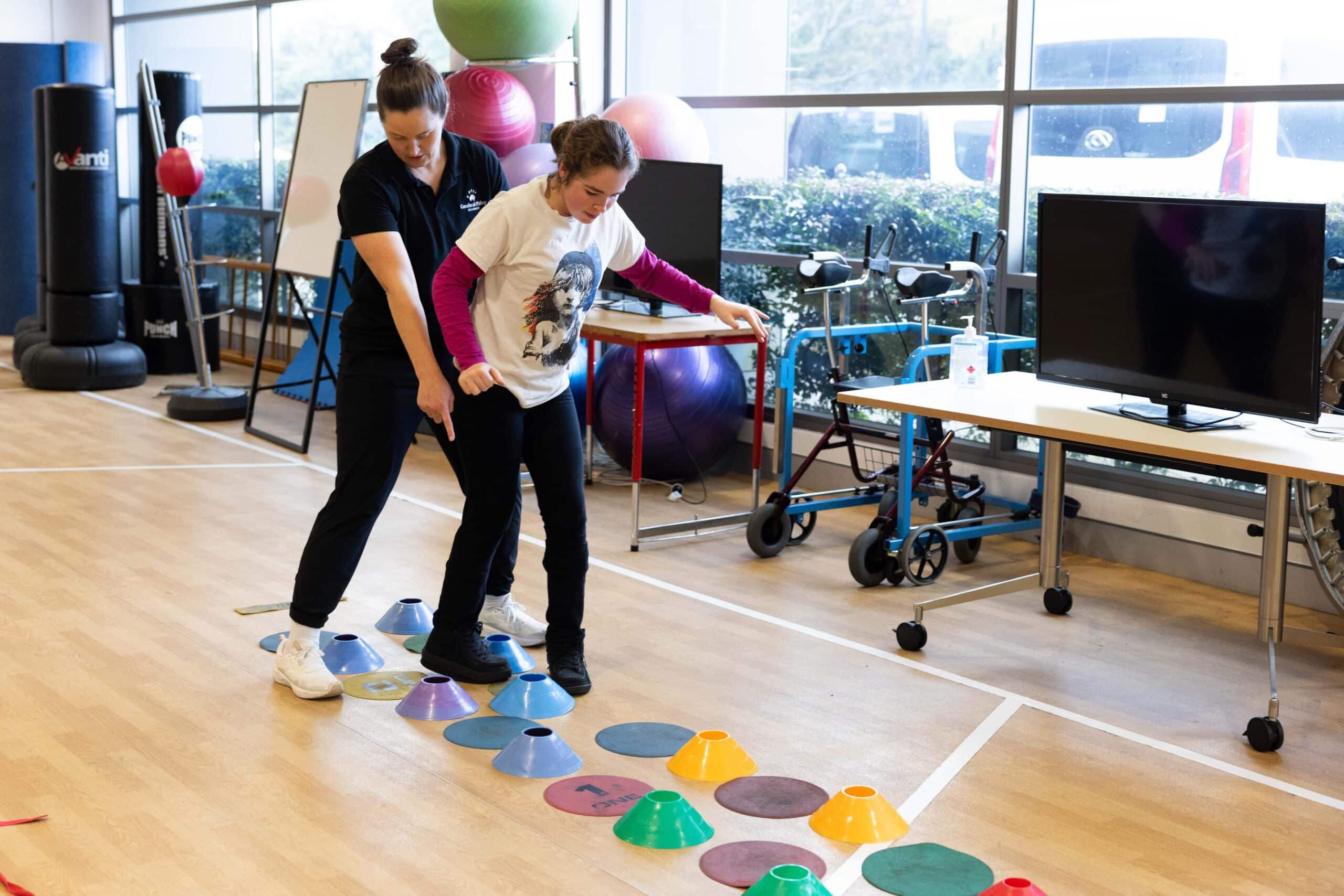 A client in the gym, working on her balance and coordination with an exercise physiologist.