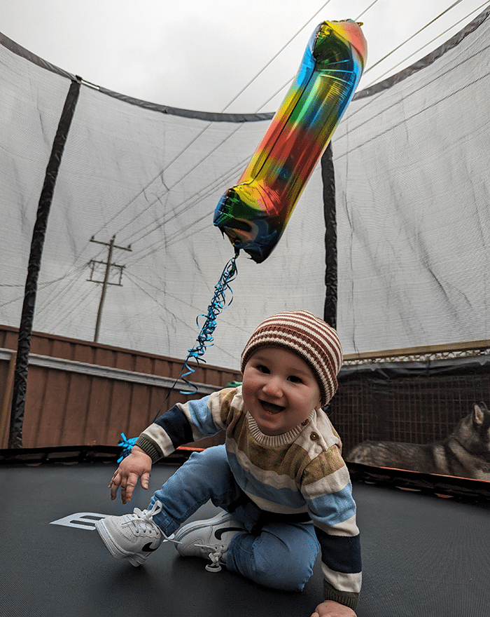 Baby Leo on a trampoline with a number 1 balloon