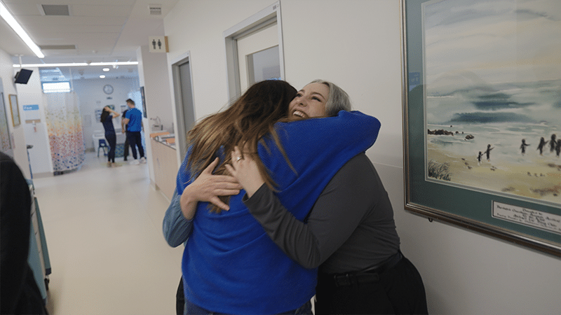 Michelle, Zara’s mum, hugs researchers Madison Paton and after the cord blood infusion.