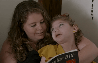 A mother reading to her child with cp.