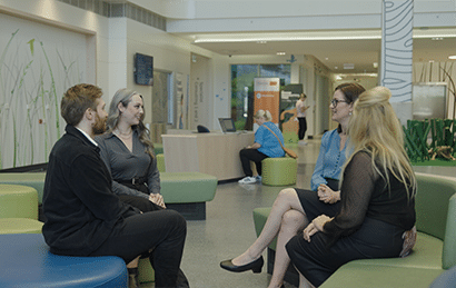 A group of colleagues sitting together on couches having a discussion.