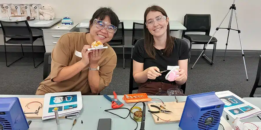 Two female participants working on toys at the switch adapt workshop