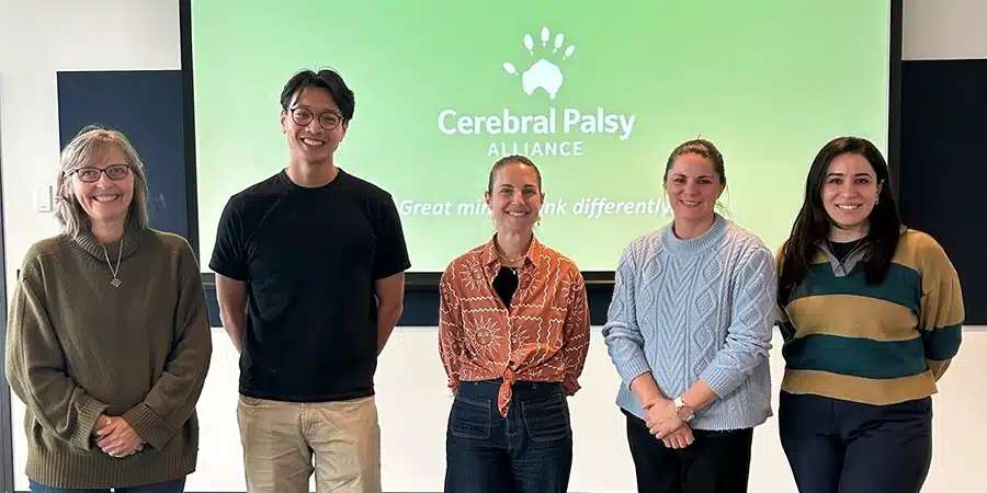 Clinician-research fellows smiling to the camera at the research translation symposium