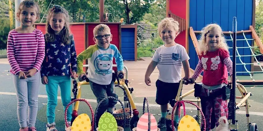 A group of young boys and girls with Cerebral Palsy, posing for a photo together in a playground
