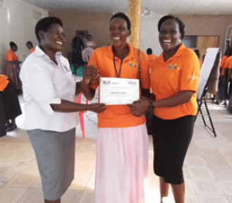 Three community health workers receiving certificates acknowledging disability identification training in Uganda