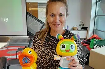 A CPA team member holding two tech toys