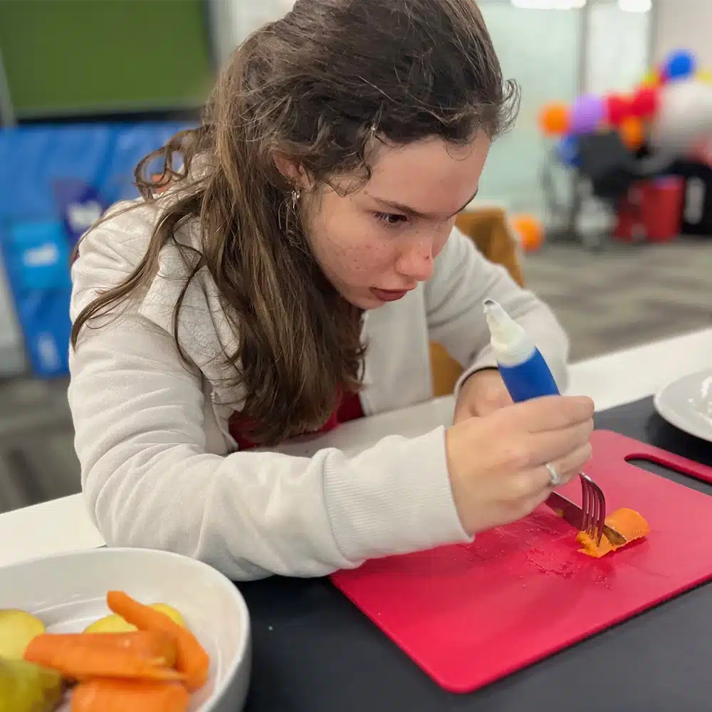 Child practising fine motor skills during CPA's HABIT-ILE intensive therapy program using a craft-based activity.