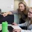 Two female researchers reviewing work on a computer screen together.