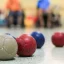 Close up of Boccia balls during a game with players in wheelchairs out of focus in the background.