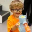 Zeek holding a bubble blowing machine and smiling to camera