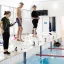 Participants of the camp lined up on diving blocks ready to swim at the swim-tri camp.