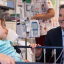 Zara sitting in her hospital bed, talking to Professor Michael Fahey sitting next to her while receiving her umbilical cord blood infusion