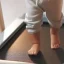 View of a baby's legs walking on a treadmill during therapy