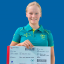 Paralympic swimmer Holly Warn holding an oversize plane ticket, smiling to camera