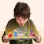 young boy looking down in wonder at 5 small animated characters stadning on top of a ipad he is holding in his hands