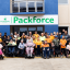 A group of supported employment workers and their disability support coordinators smiling for a photo in front of packforce