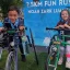 Noah and Quinn posing in their frame runners in front of the race banner