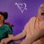 Man and woman in wheelchairs laughing to camera.