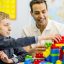 a young client playing with block with a support person