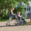 A disabled child in a wheelchair being cared for by a voluntary care worker