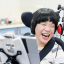 A young woman smiling, sitting in a wheelchair