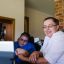 A young boy in a wheelchair with his mum in the middle of a telehealth session